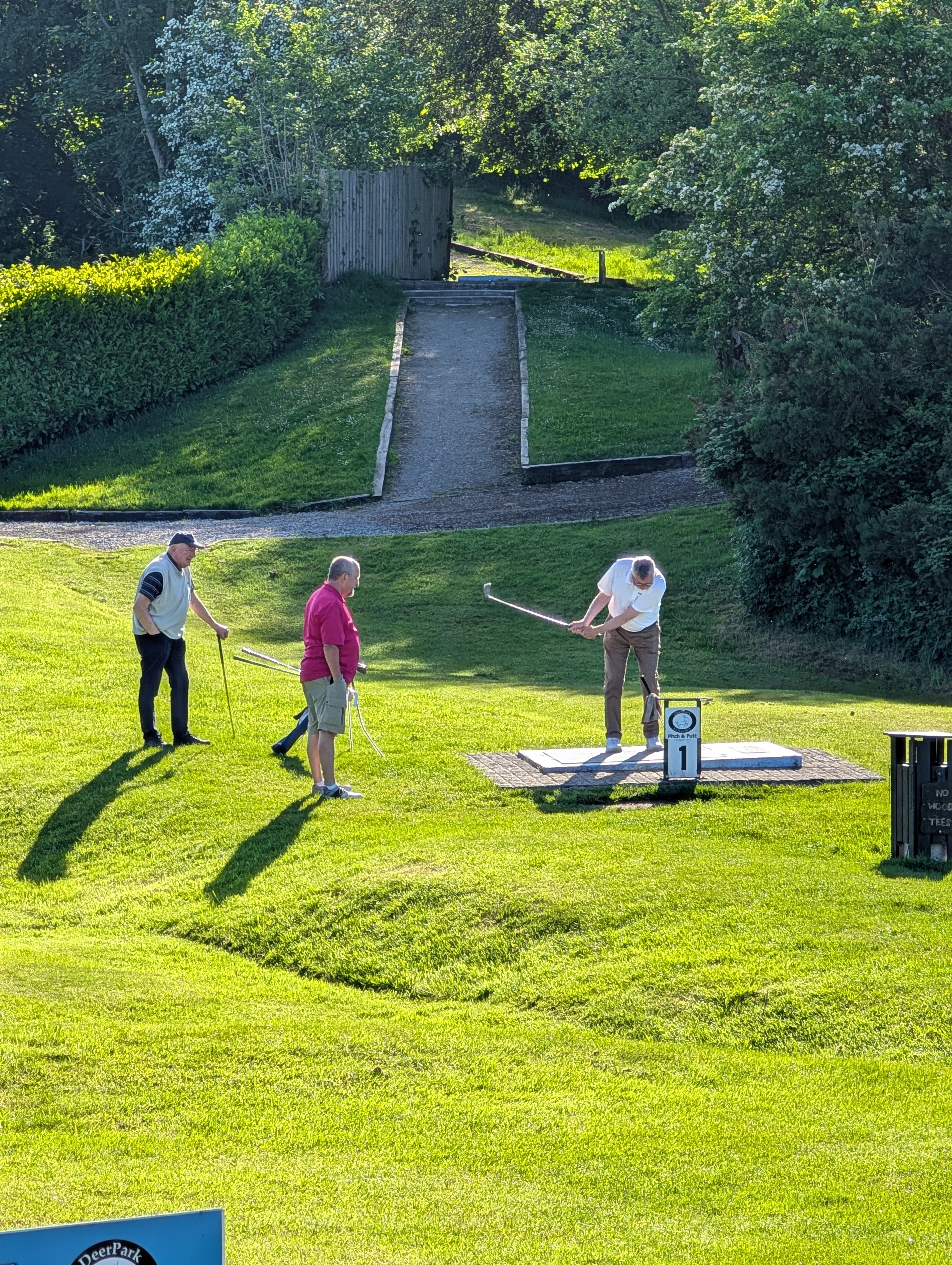 Sean Ashe teeing off, being observed by Sean O'Brien and Dave Spillane